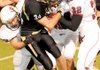 Bentonville senior Ben Nichols, No. 34, was dragged down by a trio of Springdale defenders during a kickoff during the Tigers’ 28-0 victory Friday.