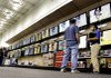 An employee (right) helps a customer looks at high-definition televisions earlier this year at a Best Buy store in Greensboro, N.C., in this file photo.