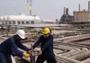 Iraqi workers operate a valve at an oil refinery in the town of Zubair about 12 miles southwest of Basra last week.