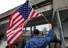 Steve Browning, who says he was an instructor pilot in the Air Force, waves a U.S. flag as the new Navy assault ship USS New York, built with World Trade Center steel, docks in New York on Monday.