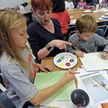 Christina Mariotti, an Arkansas artist born in Italy, helps Gabrielle Rheay, 10, and her brother Aid...