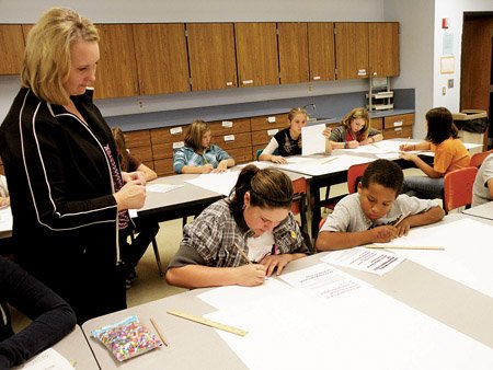 jamie-schroeder-art-instructor-at-heber-springs-middle-school-watches-as-sixth-graders-kayla-helms-center-and-orion-hulsey-practice-lettering-their-names-for-their-art-portfolios-students-rotate-into-schroeders-art-class-every-nine-weeks-and-making-portfolios-for-their-work-is-their-first-assignment