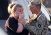 Sgt. Anthony Sills, right, comforts his wife as they wait outside the Fort Hood Army Base near Killeen, Texas, on Thursday. The Sills' 3-year old son is still in daycare on the base, which is in lock-down following a mass shooting earlier in the day.