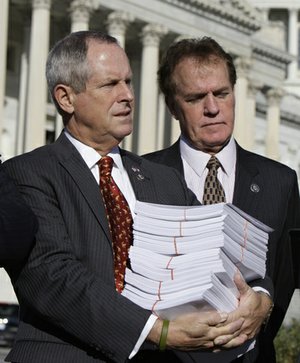 Rep. Joe Wilson, R-S.C., left, holds copy of the health care bill during a news conference on Capitol Hill in Washington, Wednesday. With him is Rep. Phil Gingrey, R-Ga.