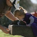 John Mauthe of Lomira, Wis., helps his niece Keira Andrews,1, of Bella Vista get a drink of water We...