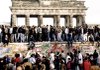 East and West Germans stand atop the Berlin Wall in front of the Brandenburg Gate on Nov. 10, 1989, the day after the wall opened.