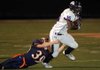 Fayetteville junior running back Dylan Hale, right, tries to escape the grasp of Rogers Heritage junior linebacker Matt White during the first half of Friday’s game in Gates Stadium in Roger