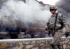 An Afghan soldier secures a road east of Kabul on Sunday after militants hit a NATO convoy. An American and two Britons died in combat elsewhere. Meanwhile, Afghan President Hamid Karzai pledged to oust corrupt officials. 