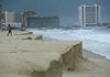 A man walks along a beach eroded from large waves after Hurricane Ida passed nearby Sunday in Cancun, Mexico.