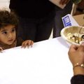 Helen Rojas, 2, of Springdale keeps a close eye on Leticia Lachino of Springdale as Lachino pours ch...