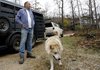 Jim Orr stands with Feather, a 7-year-old mixed-breed wolf, on Monday on his Witter Wildlife Refuge. A bank has foreclosed on the property, forcing Orr to find new homes for animals he has kept there.