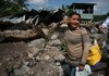 A woman in Verapaz, El Salvador, on Monday surveys her home that was destroyed by flooding.