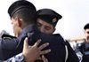 Iraqi police officers embrace during their graduation ceremony at Baghdad’s Police College at the Ministry of Interior complex Monday.