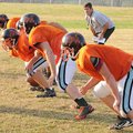 Gravette coach Bill Harrelson, background, watches as his offensive linemen works on a drill during ...