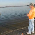 Fred Beaman of Rogers works a lure near a signpost Tuesday at the Arkansas 12 bridge access on Beave...