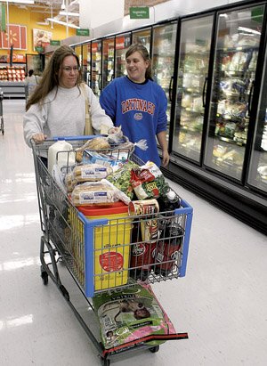 Laura Godfrey (left) and Elizabeth Godfrey shop for groceries this week at a Wal-Mart store in Rogers. The grocery segment saw almost half of Wal-Mart’s sales in the past fiscal year.