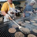 Tim Gray, left, president of HomeAid Northwest Arkansas, along with board member Phil Watt, cook bur...