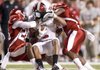Arkansas cornerback Greg Gaston (left) and strong safety Jerico Nelson (right) make a tackle on Troy wide receiver Cornelius Williams during the first quarter Saturday at Donald W. Reynolds Razorback Stadium in Fayetteville.
