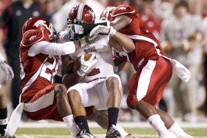 Arkansas cornerback Greg Gaston (left) and strong safety Jerico Nelson (right) make a tackle on Troy wide receiver Cornelius Williams during the first quarter Saturday at Donald W. Reynolds Razorback Stadium in Fayetteville.