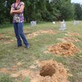 Theresa Kersey stands next to holes drilled in the ground near headstones at the Gray Cemetery north...
