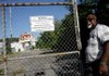 Dwight Salisbury, manager of the Southwest Radiation Calibration Center, unlocks the gate leading to the closed nuclear reactor near Strickler in 2007. An international nuclear services company has had employees on the site since Nov. 5 helping the University of Arkansas determine how to clean it up.