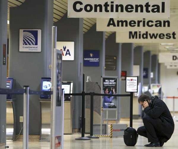 a-passenger-talks-on-his-cell-phone-in-the-terminal-at-the-des-moines-international-airport-thursday