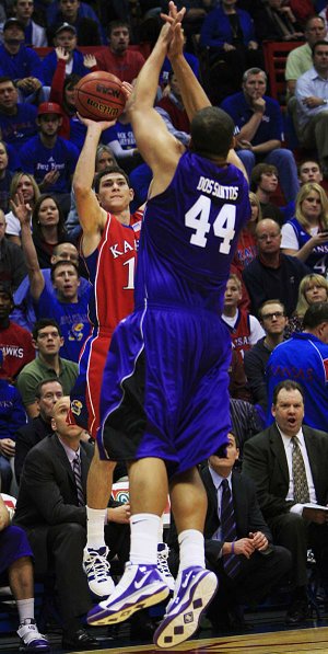 Kansas guard Tyrel Reed (left) takes a three-point shot over Central Arkansas’ Carlos Dos Santos in the first half of the Jayhawks’ 94-44 victory Thursday night. Reed had 12 points, all on three-point shots. 