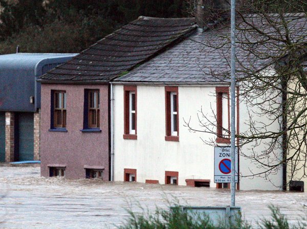 a-row-of-houses-are-seen-engulfed-by-floodwaters-after-a-heavy-rain-caused-localised-flooding-in-cockermouth-cumbria-england-friday