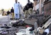 People gather near the scene of a suicide bombing Thursday outside a courthouse in Peshawar, Pakistan. 