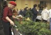 Juli Odum with Urban Jungle of Farmington, finishes a fresh wreath Saturday as shoppers browse the Bella Vista Village’s Christmas Bazaar at Riordan Hall. Vendors displayed and sold Christmas decorations and a variety of gifts during the event. 