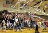 Bentonville fans throw rolls of toilet paper onto the gym floor after the first score by the Tigers on Tuesday in Bentonville.