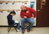 Delaney Reaves, 7, reads Friday to Chad Hicks, who is participating in Watch D.O.G.S. at the Benton County School of Arts in Rogers.
