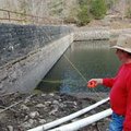 Engineer Richard Dee Purkeypile points at an 8-foot section of the Black Bass Lake dam, which was ad...