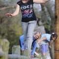 Gabby Smith, front, 11, balances herself while walking the fence post Monday at Maple Grove Park in ...