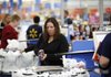 Nicole Molavi of Sewell, N.J., checks out at a Wal-Mart in Deptford, N.J., earlier this month. The Conference Board said Tuesday that shoppers’ confidence in the economy improved slightly in November.