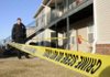 John Brashear with the Rogers Police Department puts up crime scene tape around an apartment Wednesday at the Rogers Commons Apartments.