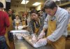 Mike Wolfe, right, of Rogers, carves turkey Thursday, Nov. 26, 2009, with Wan Wan Hao, of Kansas City, Mo., at World Garden in Bentonville. More than 100 volunteers were set to prepare about 2,400 Thanksgiving meals for area residents.

