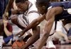 Arkansas’ Delvon Johnson dives for a loose ball with East Tennessee State’s Isiah Brown in the first half of the Buccaneers’ 94-85 victory Friday night at Walton Arena.