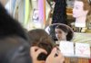 Isabella Arkins, 10, of Rogers, tries on a hair extension Nov. 22 at the Pink Pom Pom kiosk in the food pavilion at Pinnacle Hills Promenade. Isabella needed longer hair to wear during an upcoming performance of the Nutcracker.