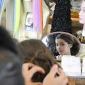 Isabella Arkins, 10, of Rogers, tries on a hair extension Nov. 22 at the Pink Pom Pom kiosk in the f...