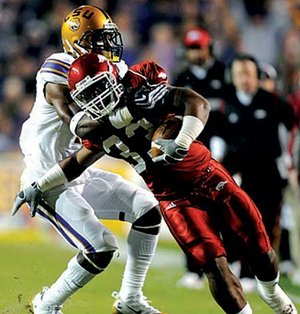 Arkansas tailback Dennis Johnson is tackled by LSU cornerback Patrick Peterson at the end of a big gain on the opening drive of the Razorbacks’ game Saturday in Tiger Stadium in Baton Rouge, La.