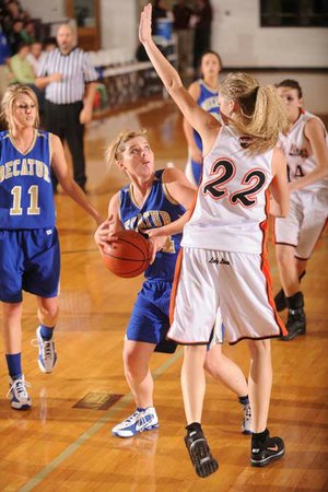 Decatur’s Tiffany Wright, center, looks to shoot as Gravette’s Kaitlynn Britton defends during the first half of Monday’s game in the Benton County Invitational Tournament at Siloam Springs High School.
