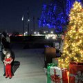 Virginia Mocivnik helps Isabella Bryan, 3, use a remote switch Monday to turn on holiday lights in f...