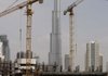 The Burj Dubai, which will be the world’s tallest building when finished, is framed by cranes standing at a construction site in the Business Bay district in Dubai, United Arab Emirates, on Monday.
