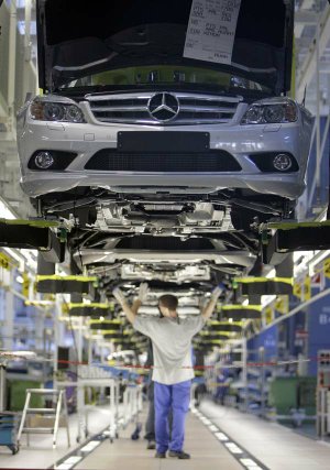 Employees of German carmaker Mercedes-Benz assemble Mercedes C-Class sedans on the production line in Sindelfingen, near Stuttgart, Germany, last year.