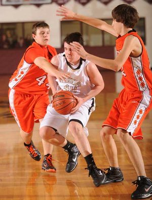 Bentonville Gold’s Garrett Kaufman, center, is pressured by Gravette’s Cody Nims, left, during Monday’s junior boys game in the Benton County Invitational at Siloam Springs.
