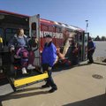 Christine Milmore of Springdale, left, is helped onto an Ozark Regional Transit bus by ORT driver Jo...