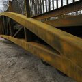 Workers maneuver a 30-ton section into place Wednesday while installing a 140-foot pedestrian bridge...
