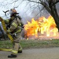 Rogers Fire Department Capt. Rob Taylor deploys hoses Wednesday at the scene of a vacant house fire ...