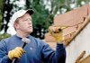 Volunteer Mike Jones of Fayetteville works to deconstruct the roof of a house on Quality Lane in Fayetteville.